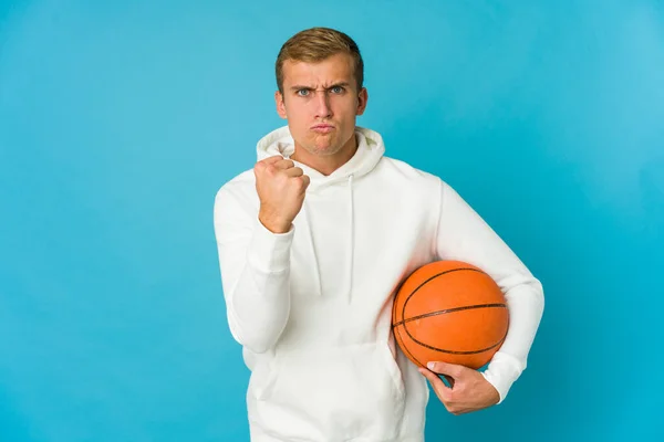 Fiatal Fehér Férfi Játszik Kosárlabda Elszigetelt Kék Háttér Mutatja Ököllel — Stock Fotó