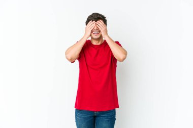 Genç, havalı adam elleriyle gözlerini kapatıyor, gülümseyerek bir sürpriz bekliyor..