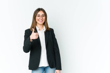 Genç beyaz iş kadını gülümsüyor ve başparmağını kaldırıyor.