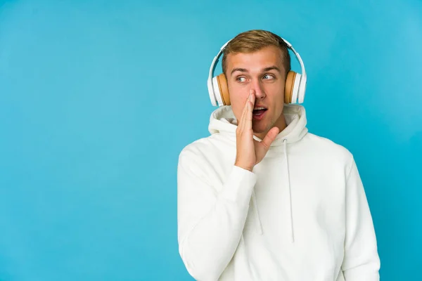 Joven Hombre Caucásico Escuchando Música Aislada Sobre Fondo Azul Tocando — Foto de Stock