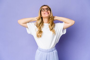 Kafkasyalı sarışın genç bir kadın kendinden emin, elleri başının arkasında..