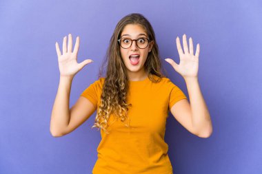 Beyaz tenli hoş bir kadın hoş bir sürpriz yapıyor. Heyecanlı ve el kaldırıyor..