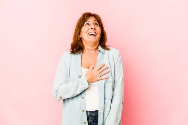 Kafkasyalı kıdemli kadın kahkahalarla gülüyor ve elini göğsüne koyuyor..