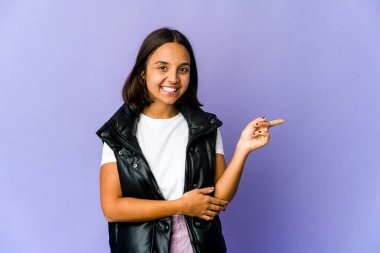 Genç melez kadın işaret parmağıyla işaret ederek gülümsüyor..