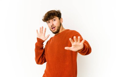 Beyaz arka plandaki genç Arap adam, yakın bir tehlike nedeniyle şoka uğruyor.