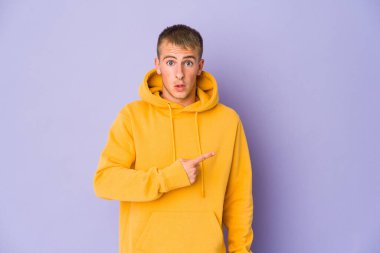 Kafkasyalı yakışıklı genç adam yan tarafı işaret ediyor.