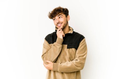 Beyaz arka plandaki genç Arap adam rahatlamış fotokopi alanına bakan bir şey düşünüyor..