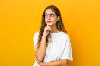 Şüpheli ve şüpheci bir ifadeyle yan bakan beyaz bir kadın..