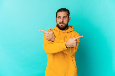 Uzun saçlı genç adam iki seçenek arasında seçim yapmaya çalışıyor..