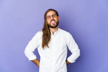 Uzun saçlı genç adam komik ve arkadaş canlısı görünüyor..