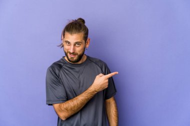 Uzun saçlı genç adam üzgün ve dalgın görünüyor, kopyalama alanına bakıyor..