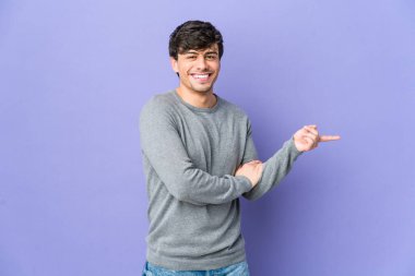 Genç, havalı adam işaret parmağıyla işaret ederek gülümsüyor..