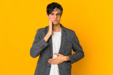 Genç, sıska İspanyol adam yanakları üflüyor. Yüzünde yorgun bir ifade var. Yüz ifadesi kavramı.