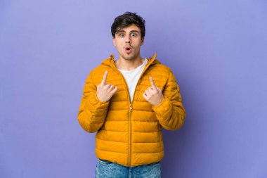 Genç havalı adam ağzı açık bir şekilde üst tarafı işaret ediyor..