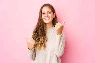 Kafkasyalı genç bir kadın iki parmağını da kaldırıyor, gülümsüyor ve kendinden emin..