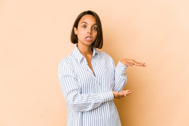 Genç İspanyol kadın şok olmuş ve hayrete düşmüş. Ellerinin arasında bir kopya alanı tutuyor..