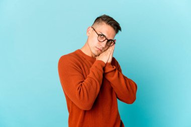 Beyaz tenli yakışıklı adam kendini izole etmiş esniyor. Ağzı eliyle kapatan yorgun bir hareket sergiliyor..