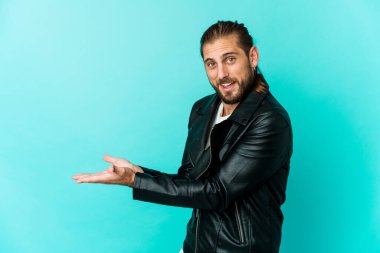 Uzun saçlı genç adam avucunun içinde bir kopya alanı tutuyor..