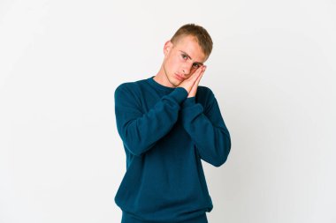 Beyaz tenli yakışıklı adam esniyor. Ağzı eliyle kapatan yorgun bir jest yapıyor..