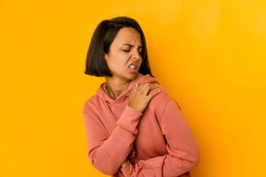 Sarıda izole edilmiş, omuz ağrısı olan genç İspanyol kadın..