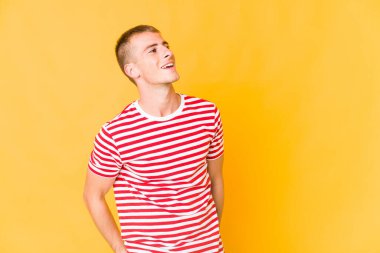 Genç beyaz yakışıklı adam gevşemiş ve mutlu gülüyor, boynunda dişler var..