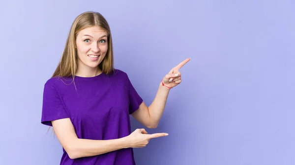 Jonge Blonde Vrouw Geïsoleerd Paarse Achtergrond Geschokt Wijzend Met Index — Stockfoto