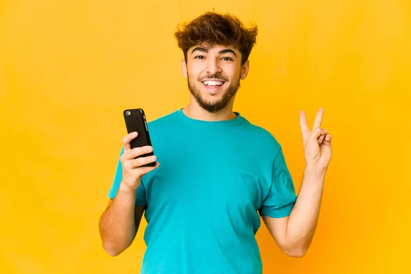 Jovem Indiano Segurando Telefone Alegre Despreocupado Mostrando Símbolo Paz Com — Fotografia de Stock