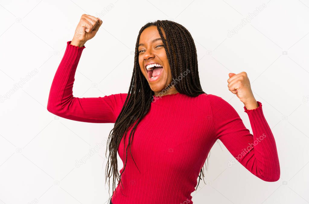 Young african american woman isolated celebrating a special day, jumps and raise arms with energy.