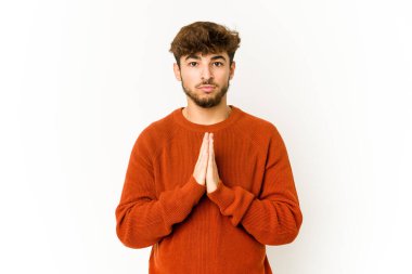 Beyaz arka planda dua eden, kendini adamış dindar, ilahi ilhamı arayan genç bir Arap..