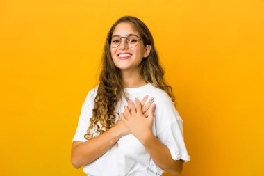 Beyaz bir kadın dost canlısı bir ifadeye sahip, avuçlarını göğsüne bastırıyor. Aşk konsepti.