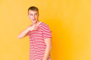 Genç beyaz yakışıklı adam gülümseyen, neşeli ve keyifli bir şekilde yana bakıyor..