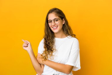 Kafkasyalı genç kadın işaret parmağıyla işaret ederek gülümsüyor..