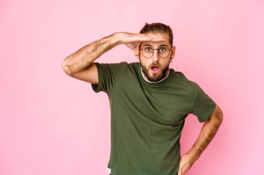 Uzun saçlı genç adam, elini alnında tutarak uzaklara bakıyor..