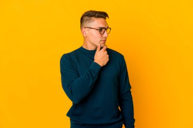 Genç, yakışıklı, beyaz tenli, soyutlanmış, kuşkucu bir ifadeyle yana bakan bir adam..