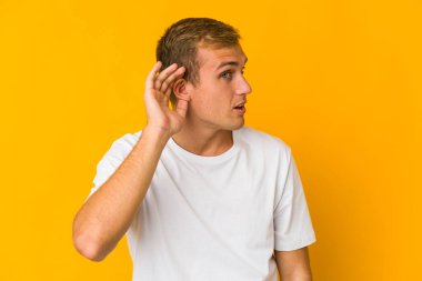 Bir dedikoduyu dinlemeye çalışan beyaz, yakışıklı genç bir adam..