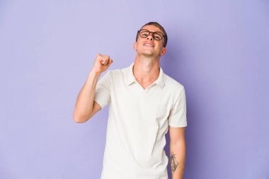 Genç beyaz yakışıklı adam zaferi, tutkuyu ve coşkuyu, mutlu ifadeyi kutluyor..