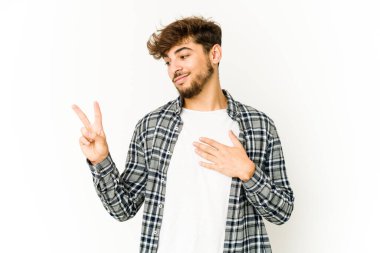 Beyaz arka planda genç bir Arap yemin ediyor, elini göğsüne koyuyor..