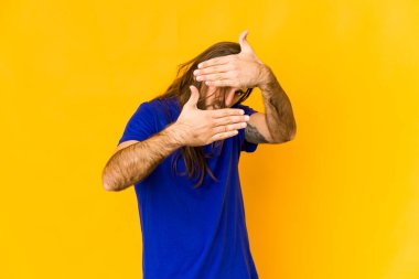 Uzun saçlı genç adam kameraya parmaklarından göz kırp, yüzünü kapatmaktan utansın..