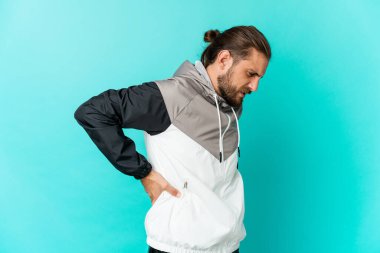 Uzun saçlı genç adam sırt ağrısı çekiyor gibi görünüyor..