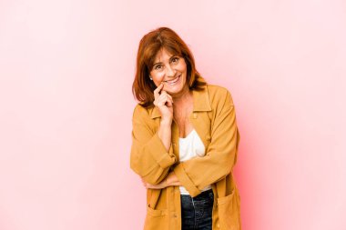 Son sınıf beyaz kadın kendini izole etmiş mutlu ve kendinden emin gülümsüyor, elleriyle çenesine dokunuyor..