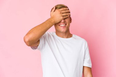 Beyaz tenli yakışıklı adam elleriyle gözlerini kapatıyor. Gülümsüyor ve bir sürpriz bekliyor..