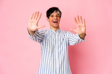 Genç, sıska, İspanyol bir adam on numarayı elleriyle gösteriyor..