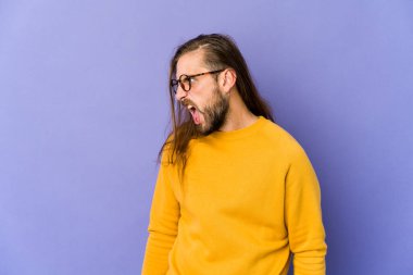 Uzun saçlı genç adam çok kızgın, öfkeli ve sinirli görünüyor..