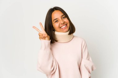 Neşeli ve tasmasız bir tasma takan genç İspanyol kadın parmaklarıyla barış sembolü gösteriyor..