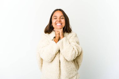 Genç melez kadın ellerini çenesinin altında tutuyor, mutlu bir şekilde yan tarafa bakıyor..