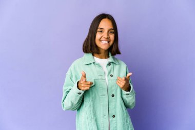 Genç melez kadın parmaklarıyla ön tarafı gösteriyor..