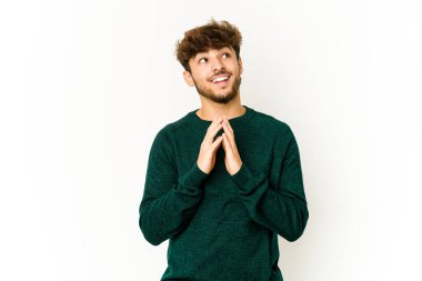 Beyaz arka planda genç bir Arap adam. Aklında bir plan kuruyor, bir fikir kuruyor..