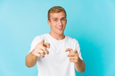 Kafkasyalı yakışıklı genç adam parmaklarıyla ön tarafı işaret ediyor..