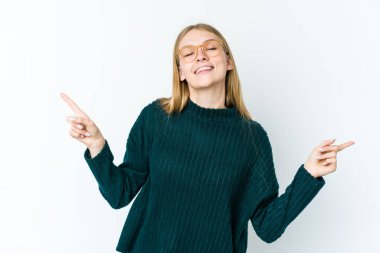 Beyaz arka planda izole edilmiş genç sarışın kadın farklı kopya alanlarını gösteriyor, birini seçiyor, parmaklarıyla gösteriyor.