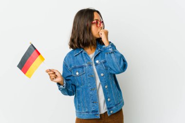 Beyaz arka planda izole edilmiş Alman bayrağı tutan genç Latin bir kadın. Ağzını eliyle kapatan bir fotokopi odasına bakıyor..